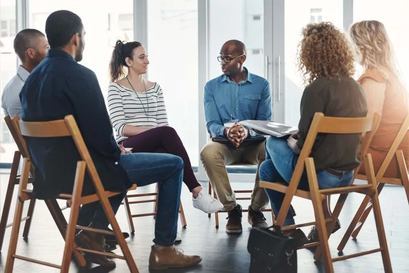 group of people sitting in a circle talking